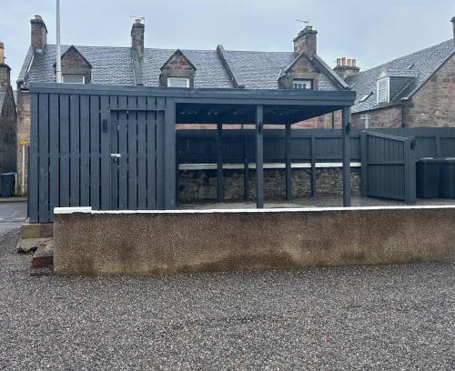 a black building with a roof on a street at Winmar Guesthouse in Inverness