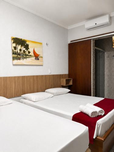 two beds in a hotel room with white sheets at Maré Praia Hotel in Fortaleza