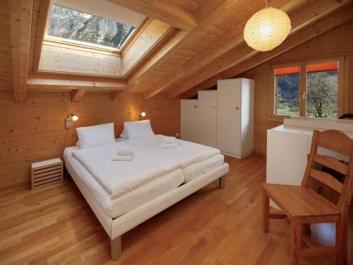 a bedroom with a large bed in a wooden house at Apartment Chalet Almisgässli by Interhome in Grindelwald