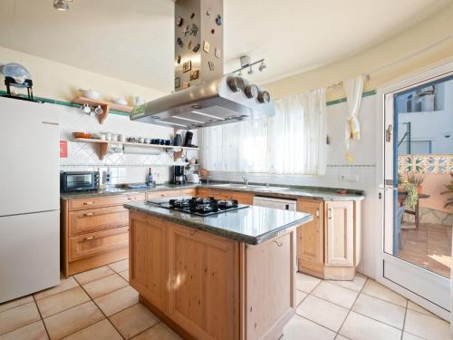 a kitchen with wooden cabinets and a stove top oven at Holiday Home Mirada al Sol by Interhome in Moraira