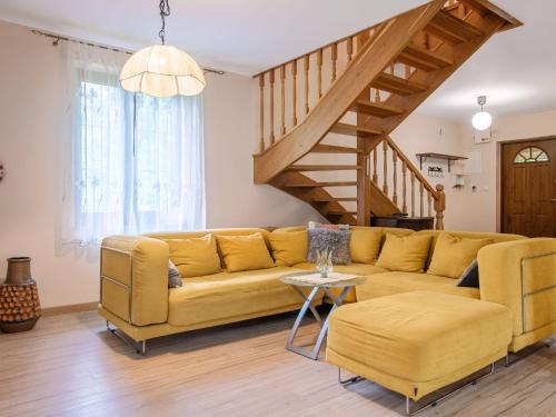 a living room with a yellow couch and a staircase at Holiday Home Borowikowa by Interhome in Sasino