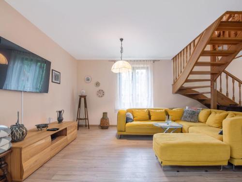 a living room with a yellow couch and stairs at Holiday Home Borowikowa by Interhome in Sasino