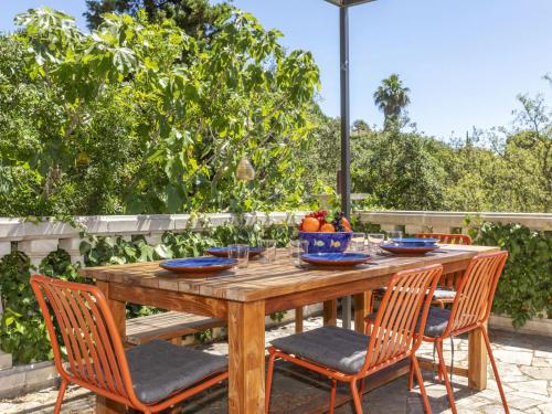 a wooden table with chairs and a bowl of fruit on it at Villa Venecia by Interhome in Calonge
