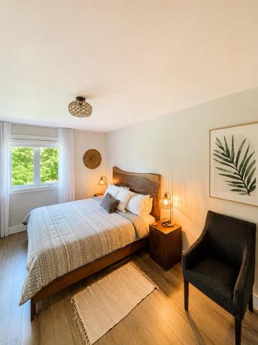 a bedroom with a bed and a chair at Le Pimbina in Mont-Tremblant