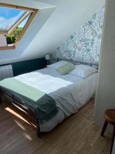 a bedroom with a large bed with a window at Chambres d'hôtes de l'Eau dit Sée in Cuves
