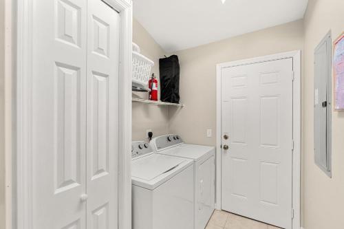 a white laundry room with a washer and dryer at Paradise Vacay in Sebastian