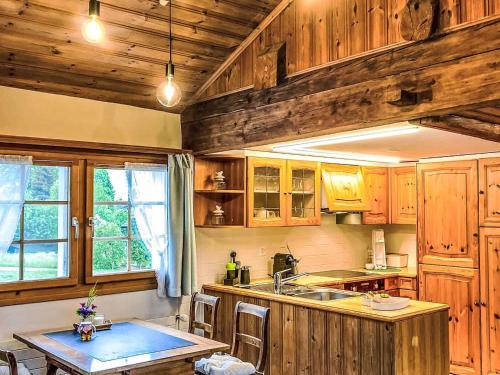 a kitchen with wooden cabinets and a sink and a table at Apartment Scheftenau by Interhome in Wattwil