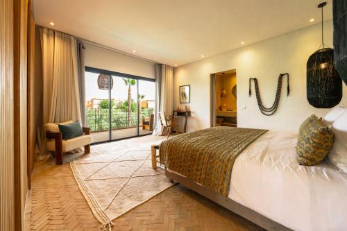 a bedroom with a large bed and a large window at Villa Madjha Ecolodge Marrakech in Marrakesh