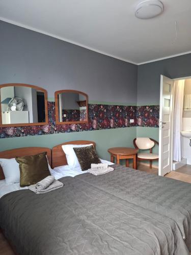 a bedroom with a large bed and two mirrors at L&B House in Malbork