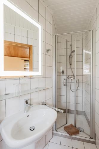 a white bathroom with a sink and a shower at Gäste-Haus Rösch in Wiesent