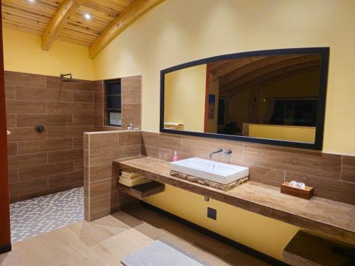 a bathroom with a sink and a large mirror at Auas Safari Lodge in Windhoek