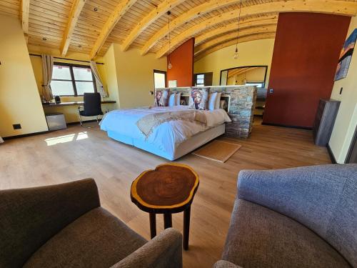 a bedroom with a bed and two couches at Auas Safari Lodge in Windhoek