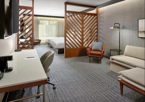 a hotel room with two beds and a chair at Courtyard by Marriott Birmingham Grandview in Birmingham