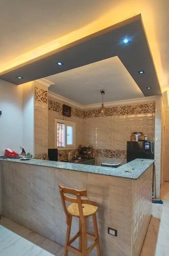 a kitchen with a bar with a wooden stool at Um yousef house in Alexandria