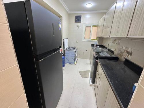 a kitchen with a black refrigerator in the middle at Um yousef house in Alexandria