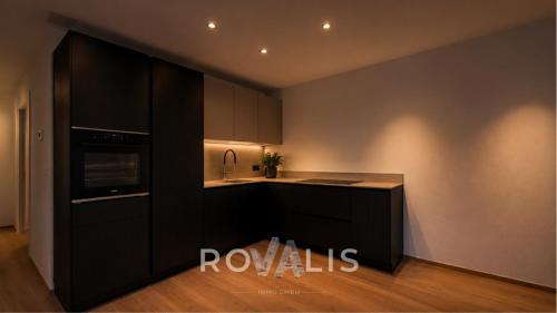 a kitchen with black cabinets and a microwave at Private Panorama Spa Brig in Brig