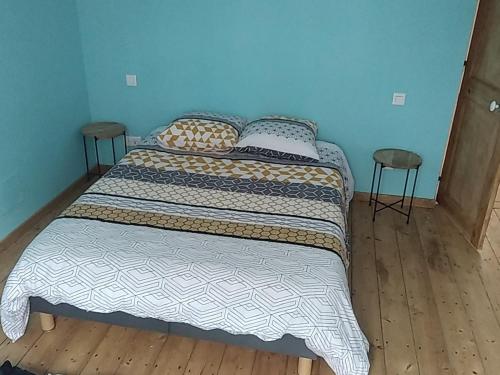 a bed in a bedroom with two stools at the end of it at La mouche de mai in Fécamp