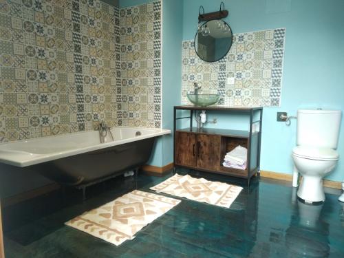 a bathroom with a tub and a toilet at La mouche de mai in Fécamp
