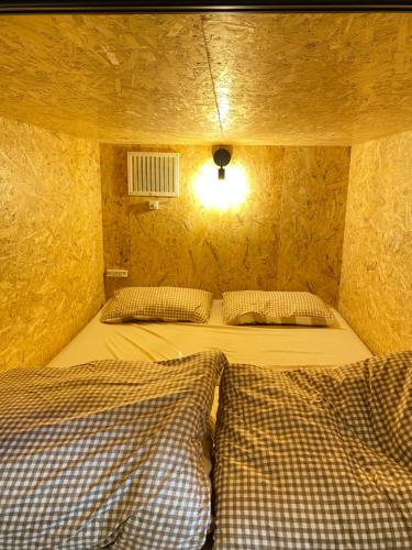 a room with two beds in a small room at Guest House SOL in Hiraisomachi