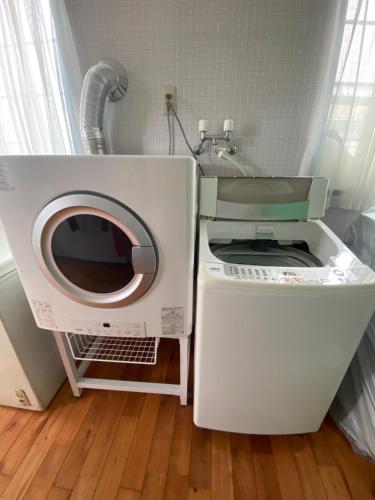 a washing machine and a dryer in a room at Guest House SOL in Hiraisomachi