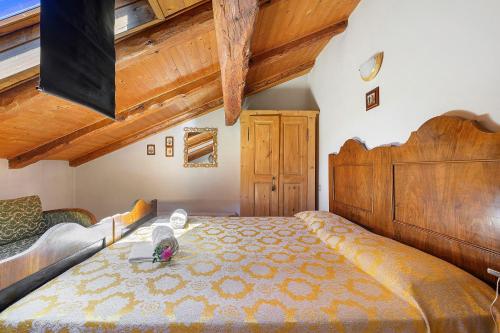 a bedroom with a large bed and wooden ceilings at Agriturismo Odorizzi in Tassullo
