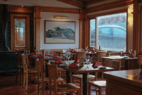 a restaurant with tables and chairs with red napkins on them at Hostal del Bosque in Ushuaia