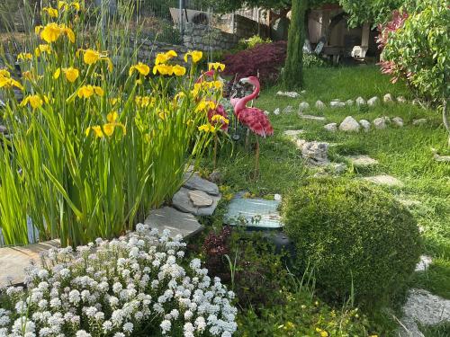 a garden with a pink flamingo and some flowers at Вила Рак-Апартаменти за гости in Varna City