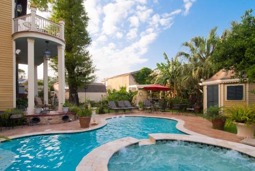 una piscina con terrazza e una casa di HH Whitney House - A Bed & Breakfast on the Historic Esplanade a New Orleans