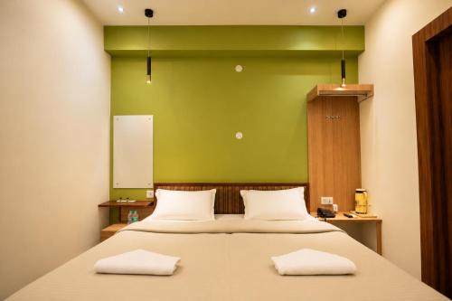 a bedroom with a bed with a green wall at Subhash Hotel in Prayagraj