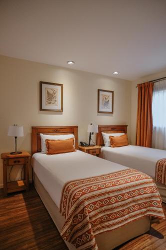 a hotel room with two beds and a window at Hostal del Bosque in Ushuaia