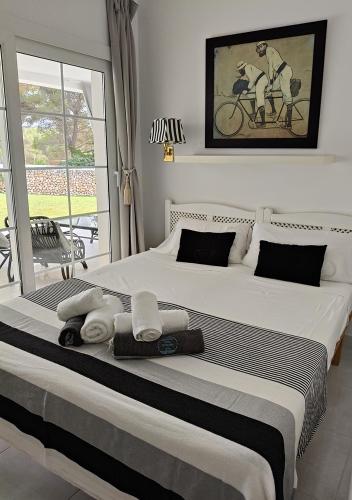 a bedroom with a large bed with towels on it at Menorca Villa Marbella in Son Parc