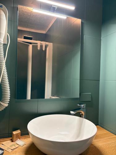 a large white tub in a bathroom with a mirror at Hotel Regina Yeti Bistrot in Sestola