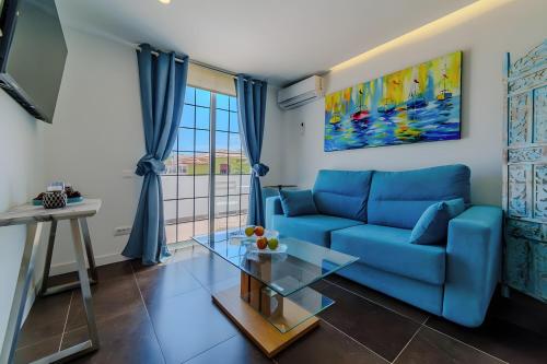 a living room with a blue couch and a glass table at Villa De Marcos in Arona
