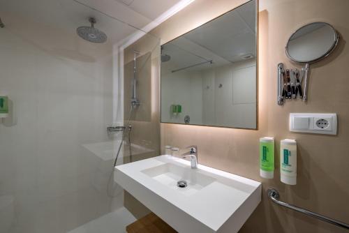 a bathroom with a sink and a mirror at Hotel Agamenón in Es Castell