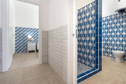 a bathroom with a toilet and blue and white tiles at Casa Canzatora in Sperlonga