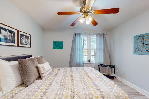 a bedroom with a ceiling fan and a bed at Cypress Cove 111 in Melbourne