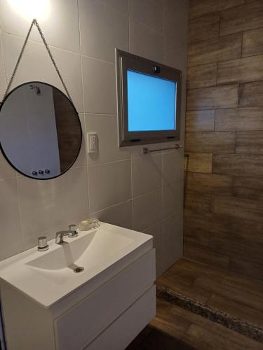 a bathroom with a sink and a tv on the wall at Quincho Lelita in Zonda