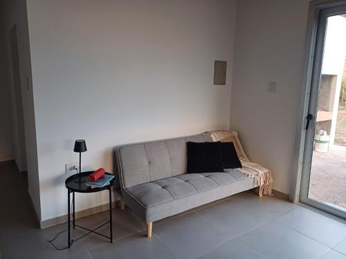 a couch in a room with a table and a window at Quincho Lelita in Zonda