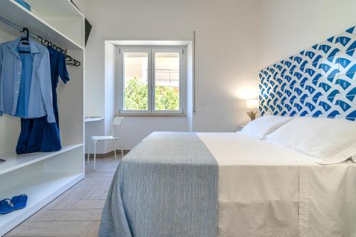a bedroom with a bed with a blue headboard and a window at Casa Canzatora in Sperlonga