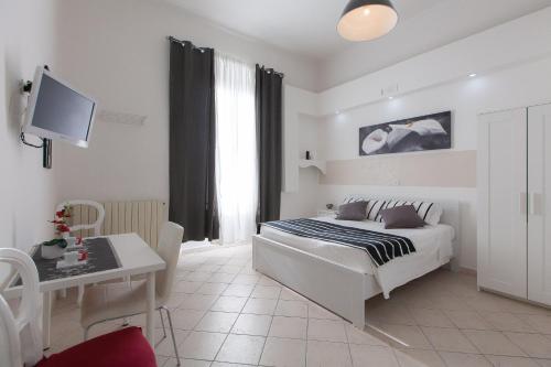 Schlafzimmer mit einem Bett, einem Tisch und einem Schreibtisch in der Unterkunft San Peter Angels in Rom