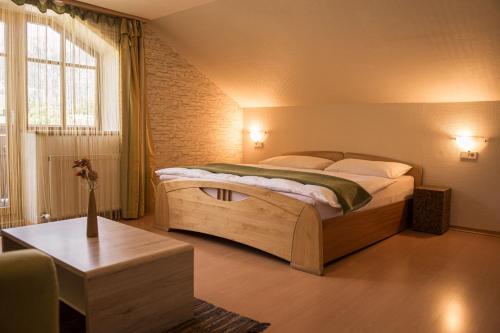 a bedroom with a large bed and a table at Landhaus am Hügel in Bad Gastein