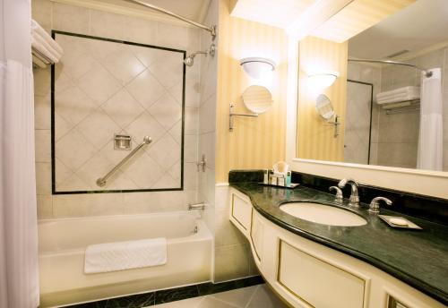 La salle de bains est pourvue d'un lavabo, d'une baignoire et d'un miroir. dans l'établissement Barceló San Salvador, à San Salvador