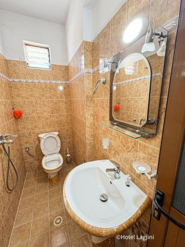 a bathroom with a sink and a toilet and a mirror at Kompleks Angjelo in Lukovë