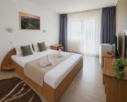 a bedroom with a large bed and a television at Pensiunea Moldova in Piatra Neamţ