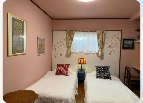 two beds in a room with a window at Eishinan 栄進庵 in Fuji
