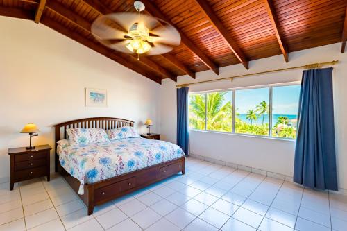 a bedroom with a bed and a large window at Antigua Village Beach Resort in Saint Johnʼs