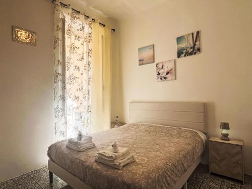 a bedroom with a bed with towels on it at Apartment casa JS by Interhome in Imperia