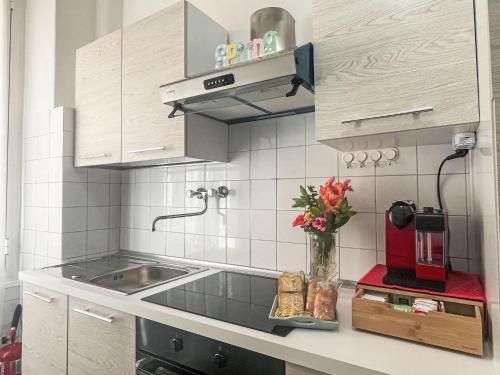 a kitchen with a sink and a vase of flowers at Apartment casa JS by Interhome in Imperia
