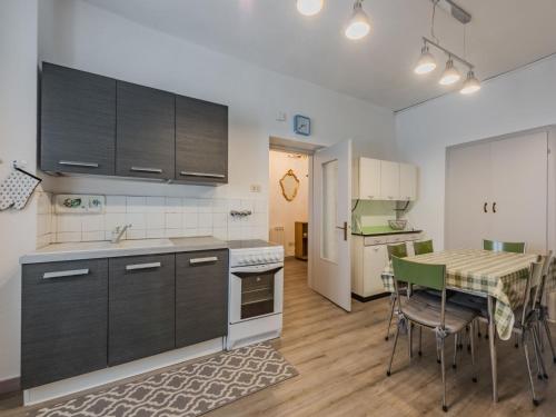 a kitchen with black cabinets and a table with chairs at Apartment Catherine by Interhome in Pellizzano