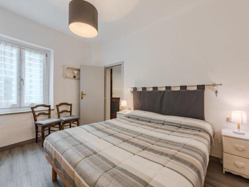 a bedroom with a large bed and two chairs at Apartment Catherine by Interhome in Pellizzano